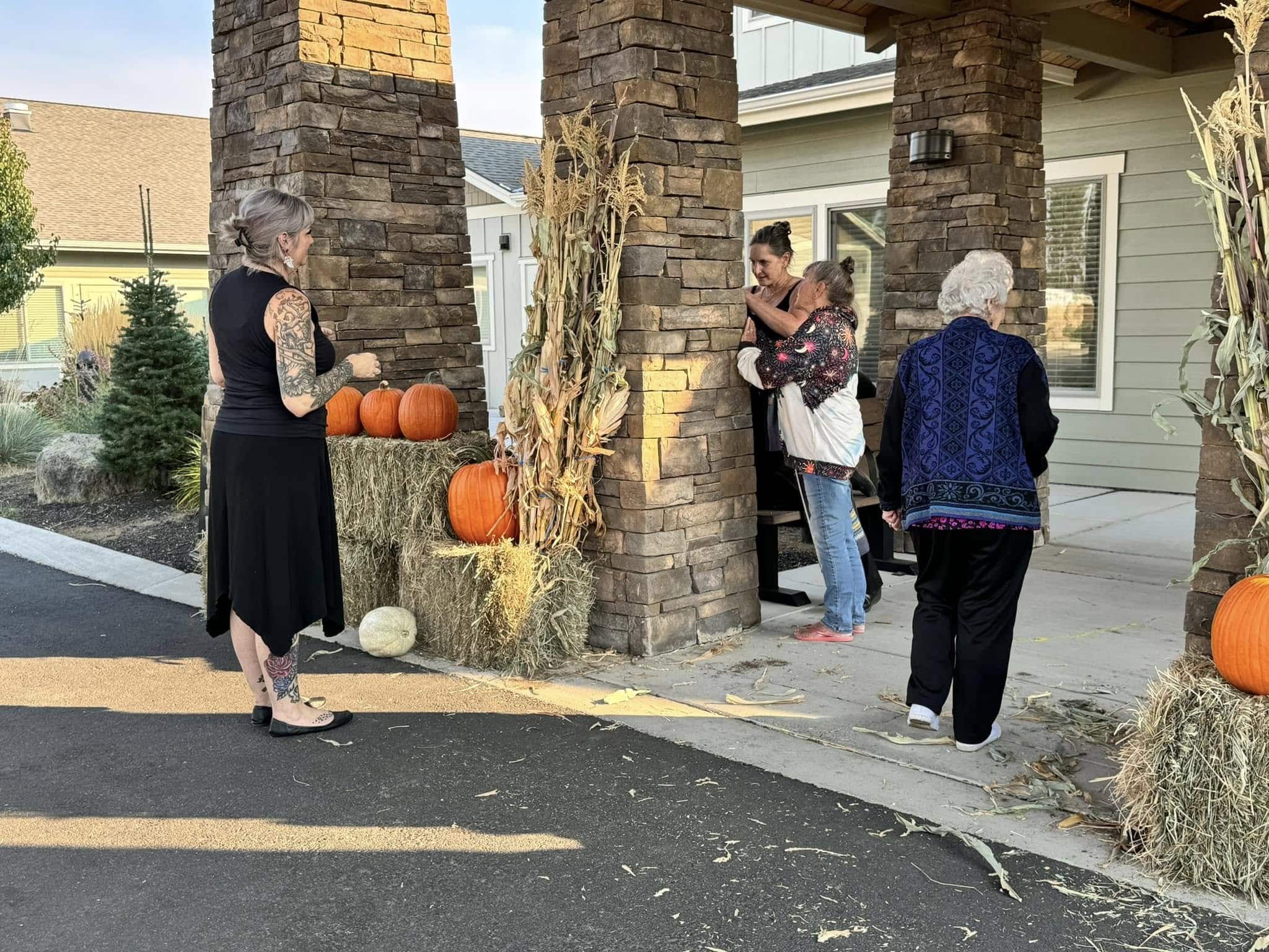 Residents and team members at The Lodge Retirement Community in Sisters, Oregon enjoy a cozy autumn afternoon surrounded by pumpkins and fall decorations.